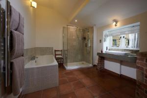 a bathroom with a tub and a shower and a sink at The Old Wash HouseChatsworth Estate in Baslow