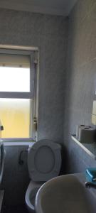a bathroom with a toilet and a sink and a window at Apartamento Mirando al Mar in San Juan de la Arena +14 photos
