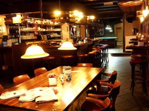 a restaurant with a long wooden table and chairs at Hotel 't Anker in Leeuwarden
