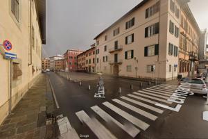 a street with a crosswalk in the middle of a city at Domus '400 in Pisa