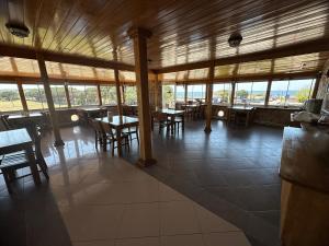 a dining room with tables and chairs and windows at Odunluk Tas Konak Hotel in Dalyanköy