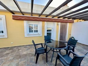 a patio with a glass table and chairs at Impresionante Ático en Torre del Mar frente al Mar in Torre del Mar