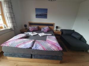 a bed and a couch in a bedroom at Ferienwohnung am Steínbrecherhof in Bad Mitterndorf