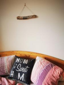 a sign hanging on a wall above a couch with pillows at Ferienwohnung am Steínbrecherhof in Bad Mitterndorf