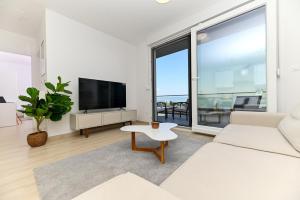 a living room with a white couch and a tv at Luxury Apartment Skyline in Split