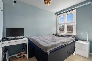 クリスティアンサンにあるPenthouse Apartmentのベッドとパソコン付きの机がある寝室
