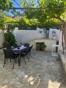a patio with a table and chairs under a tree at Holiday Home Kristin in Mirce +23 photos