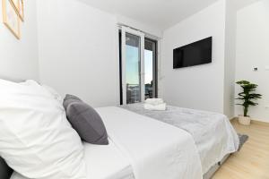 a white bedroom with a white bed and a window at Luxury Apartment Skyline in Split