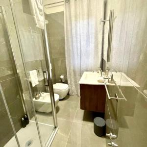 a bathroom with a toilet and a sink and a shower at Aquada Experience in Francavilla al Mare