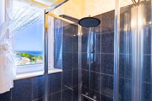 a bathroom with a shower with a window at Mare In Vista in Capoliveri