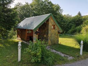 a small stone dog house with a green roof at Bungalov Živković in Mojkovac