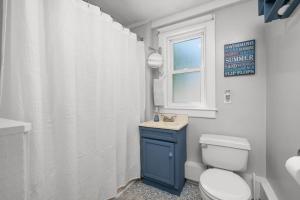 ein Badezimmer mit Toilette und Waschbecken und einem Fenster in der Unterkunft 5 Beach Road East Sandwich - Sandy Toes & Salty Kisses in East Sandwich + 20 Fotos