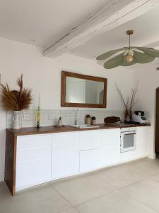 a white kitchen with a sink and a mirror at Villa Boho Cassis in Cassis
