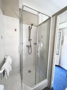 a shower with a glass door in a bathroom at Le National in S&egrave;te