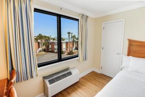 une chambre avec un lit et une grande fenêtre dans l'établissement Beach Bound 3rd Floor Resort View Lodge Room, à Pawleys Island