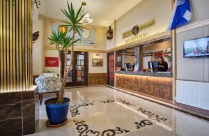 a lobby of a hotel with a palm tree in the center at Muthu Oban Regent Hotel- Refurbished in Oban
