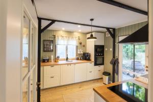 a kitchen with white cabinets and a counter top at Romantisches Cottage mit Sauna, Terrasse & Natur in Münchsteinach