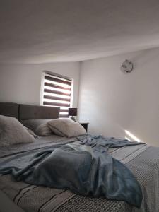 Una cama con una manta encima en un dormitorio. en Apartman Ivano, en Krnica