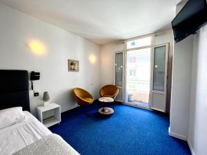 a bedroom with two chairs and a bed and a window at Le National in S&egrave;te