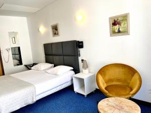 a hotel room with a bed and a chair at Le National Sète Centre Gare,Ascenseur in Sète