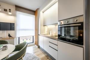 a kitchen with white cabinets and a table with a dining room at Tiny House Tower in Fidenza