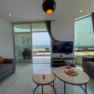 sala de estar con sofá y TV en Almasarat Tower Sea View, en Yeda