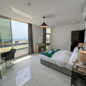 a bedroom with a large bed and a large window at Almasarat Tower Sea View in Jeddah