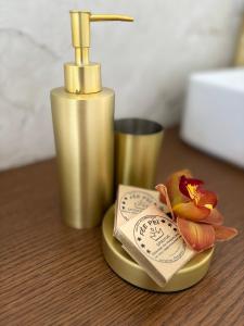 a gold soap dispenser and a flower on a table at L'Ecrin PEI in Entre-Deux +7 photos
