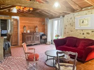 a living room with a red couch and a table at Le Clos des Écorcins - Terrasse - Parking privé in Saint-Amand-sur-Sèvre