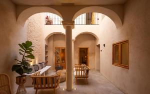 a hallway with arches and a table and chairs at VICTORIA - by Ático73 in Medina Sidonia