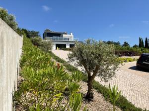 ein Haus mit einem Baum vor einer Einfahrt in der Unterkunft Villa 33 Silver Coast in Nadadouro