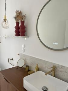 a bathroom with a white sink and a mirror at L'Ecrin PEI in Entre-Deux