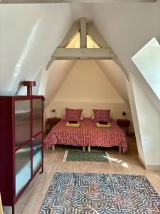 Cette chambre mansardée comprend un lit et un tapis. dans l'établissement Le Charmant Au cœur de Dieppe 2ème étage 6 personnes, à Dieppe