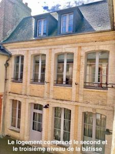 - un grand bâtiment en briques avec des fenêtres donnant sur une rue dans l'établissement Le Charmant Au cœur de Dieppe 2ème étage 6 personnes, à Dieppe