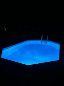 a blue swimming pool lit up at night at CASA ANGELA in Dervio