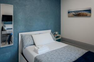 a small bedroom with a bed and a mirror at Capitani Guest House in Fiumicino