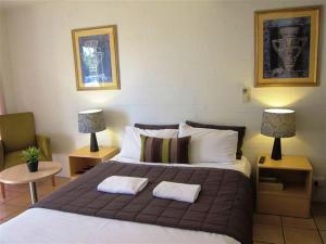- une chambre avec un grand lit et 2 oreillers dans l'établissement Horizons Motel, à Gold Coast