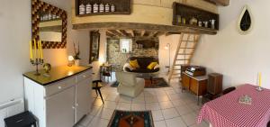 Una cocina y una sala de estar con un sofá y una mesa. en Gîte les vallées, en Sourdeval