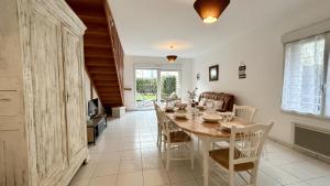 ein Esszimmer mit einem langen Tisch und Stühlen in der Unterkunft L'échappée in Fort-Mahon-Plage + 25 Fotos