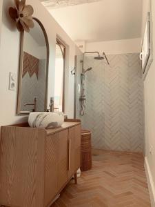 a bathroom with a shower and a sink and a mirror at Villa Boho Cassis in Cassis