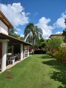 a yard with tables and a palm tree at Pousada Caribe in Itacimirim