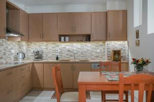 a kitchen with wooden cabinets and a table with chairs at Villa Evita in Ratzaklíon