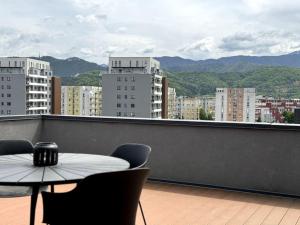 - Balcón con mesa, sillas y edificios en Skylark - Tokyo Penthouse with Jacuzzi, Movie Theater & Panoramic View, en Brasov