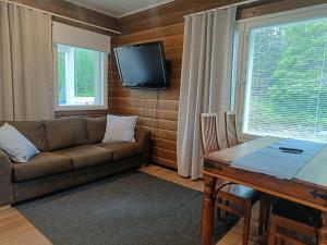 ein Wohnzimmer mit Sofa, Tisch und Fernseher in der Unterkunft 4B in Syöte