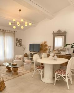 a living room with a table and chairs and a tv at Villa Boho Cassis in Cassis +10 photos