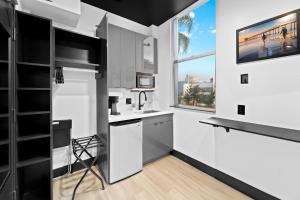 a kitchen with white appliances and a window at Balboa Park Hotel in Downtown Little Italy in San Diego