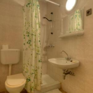 a bathroom with a toilet and a sink and a shower at Retro Nádas Vendégház in Balatonlelle
