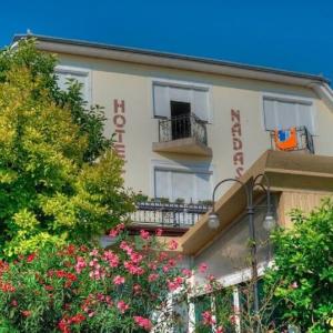 a building with a balcony and flowers in front of it at Retro Nádas Vendégház in Balatonlelle