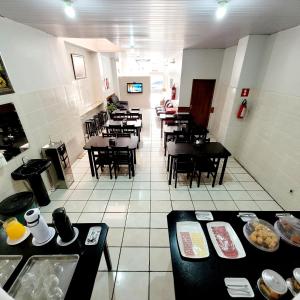 a dining room with tables and chairs in a restaurant at Hotel Aliança in Limeira +11 photos