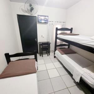 a room with two bunk beds and a table and chairs at Hotel Aliança in Limeira
